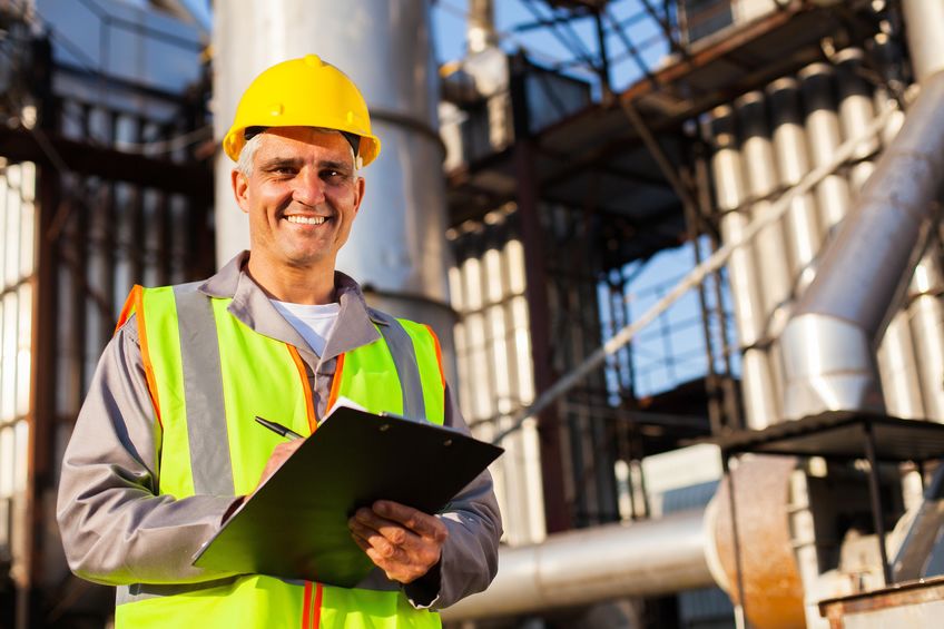 happy middle aged oil industry worker in refinery plant