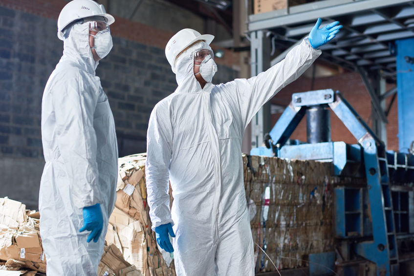 Workers in Hazmat Suits at Modern Factory